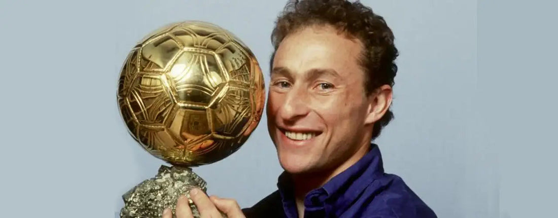 Smiling man holding large golden Ballon d'Or trophy, sports fashion vibe, Players Couture