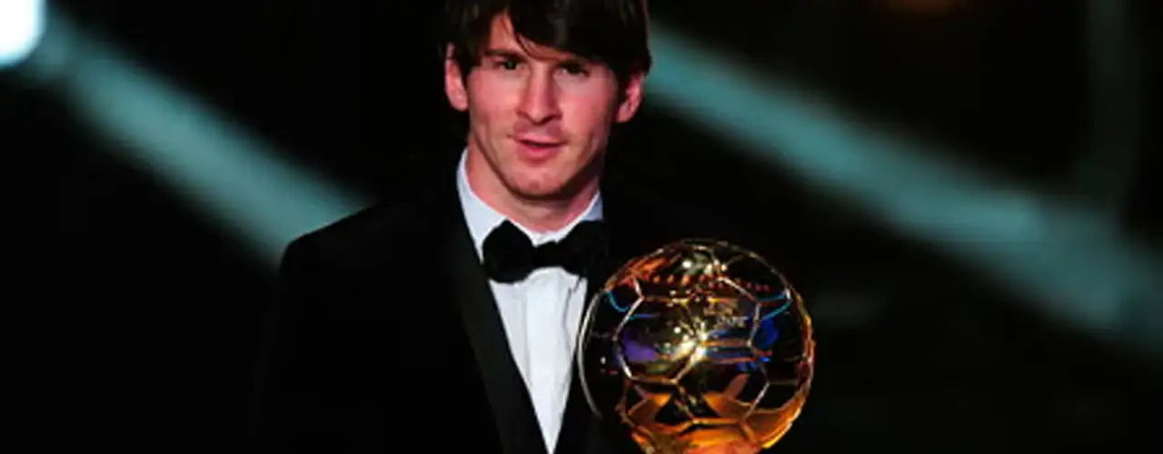 Soccer player in tuxedo holding golden Ballon d'Or trophy at awards ceremony