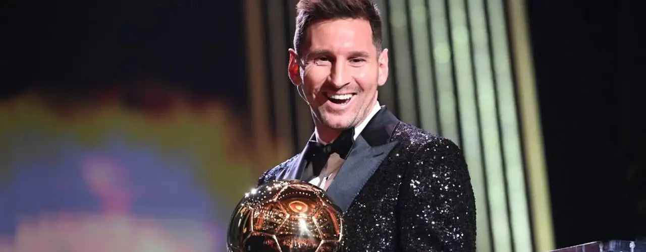 Smiling athlete in a black sequined tuxedo holding a gold sports trophy at an awards event