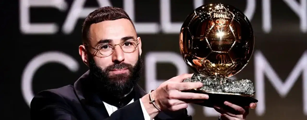 Man in suit holding Ballon d'Or trophy, stylish sports fashion, Players Couture style