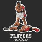 Muhammad Ali Badge Men's Hoodie – black close-up detail shot of the Muhammad Ali Players Couture logo design