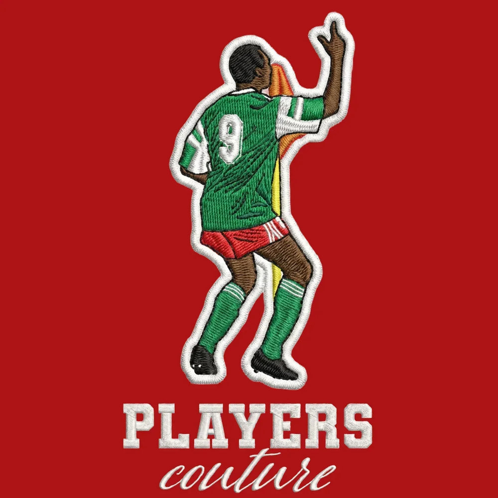 Roger Milla Badge Men's Hoodie – red close-up detail shot of the Roger Milla Players Couture logo design